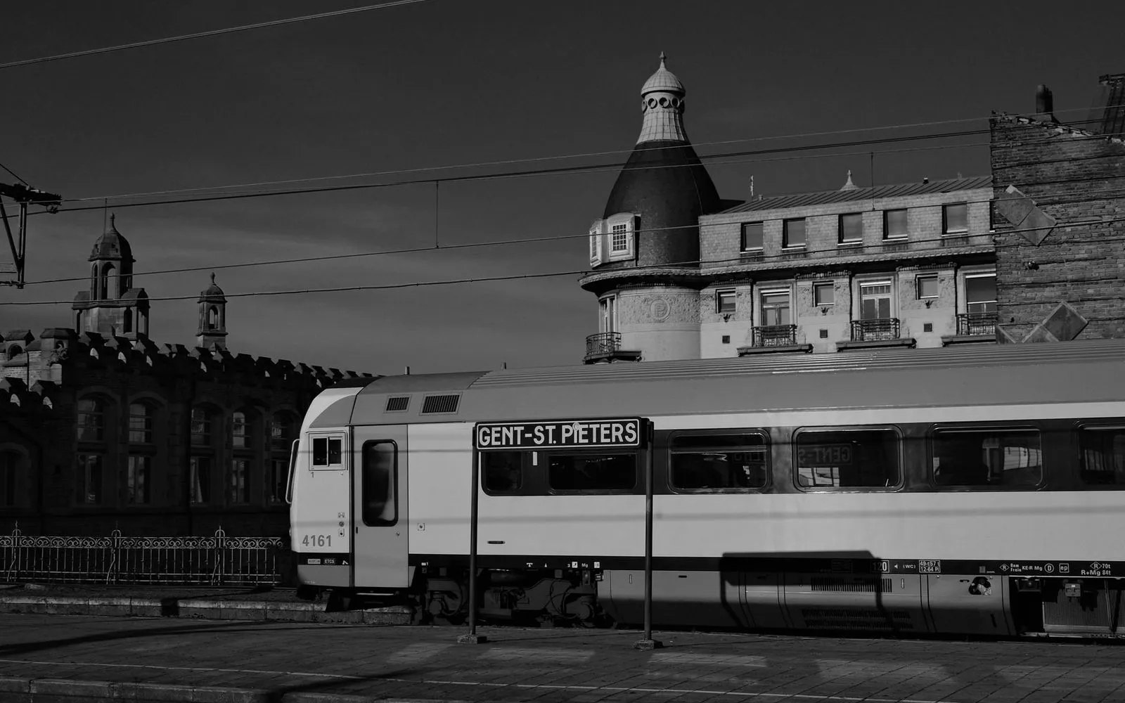 Black and white photo of Gent-St. Pieters train at historic station in Ghent, Belgium.